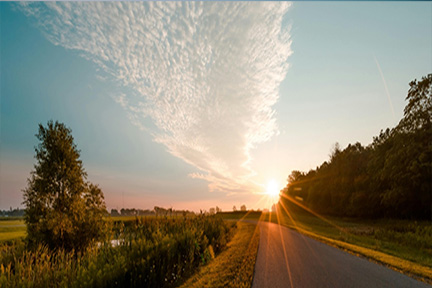 Empty land with a stretch of road illuminated by the low sun