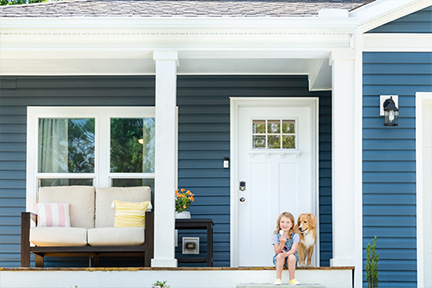 Girl sitting on a porch step with a family dog
