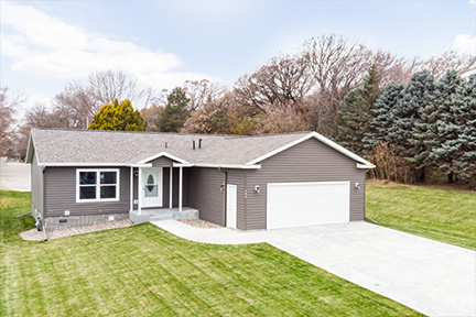 Manufactured home with gray siding and an attached garage