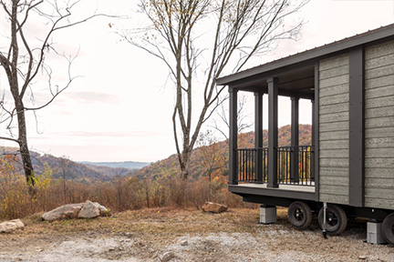 Back of a mobile home overlooking a forested mountain range